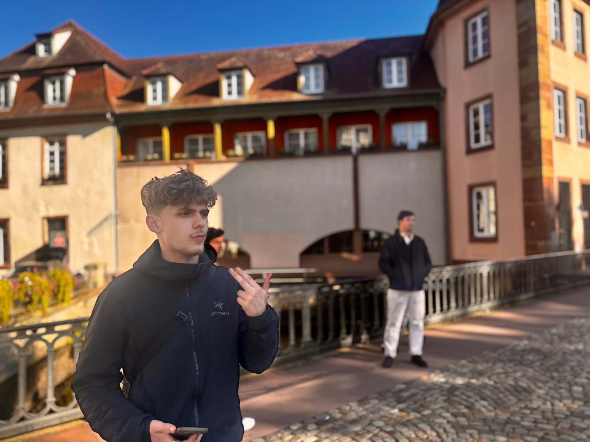 A student on a bridge on a bright autumn day